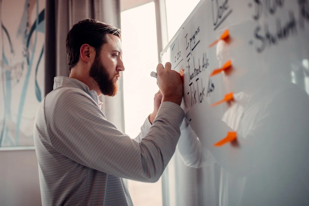 A modern workspace showing hands analyzing marketing data on a laptop and paper documents.